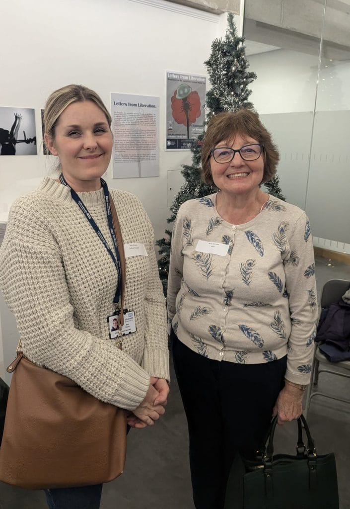 Two women smiling and chatting at a gallery networking event