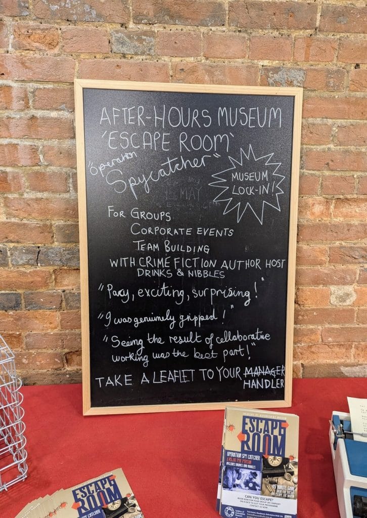 Chalkboard sign with handwritten text displayed in a venue corner