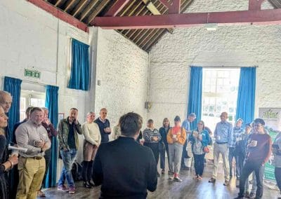 Group of attendees gathered inside a wooden-beamed barn-style hall