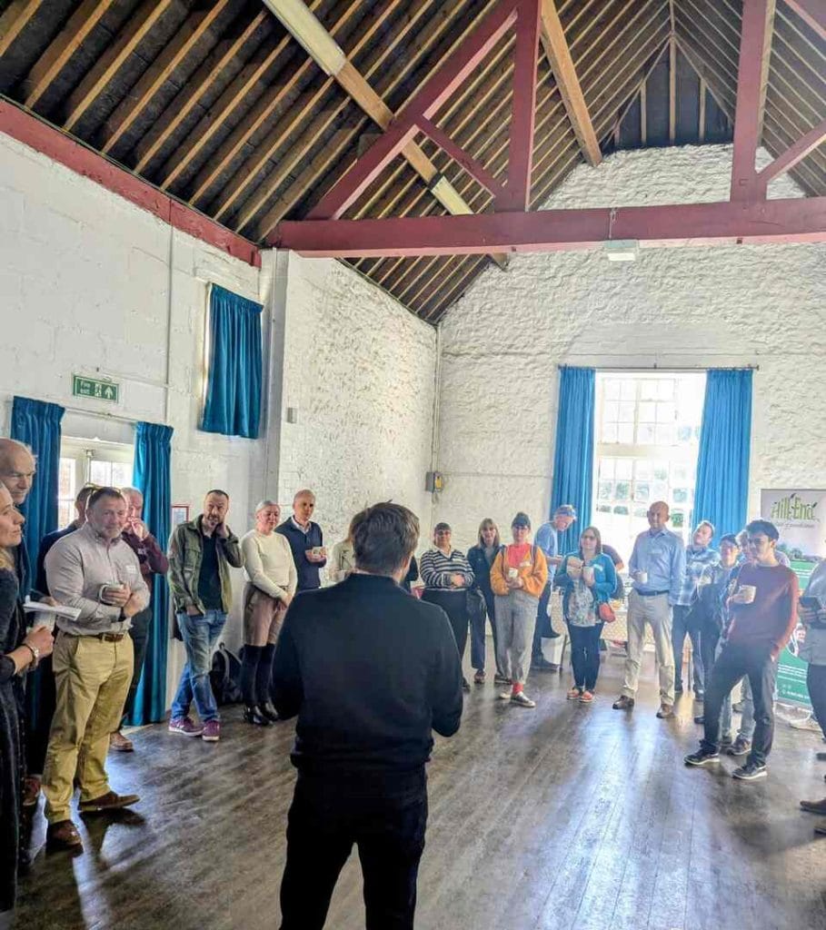 Group of attendees gathered inside a wooden-beamed barn-style hall