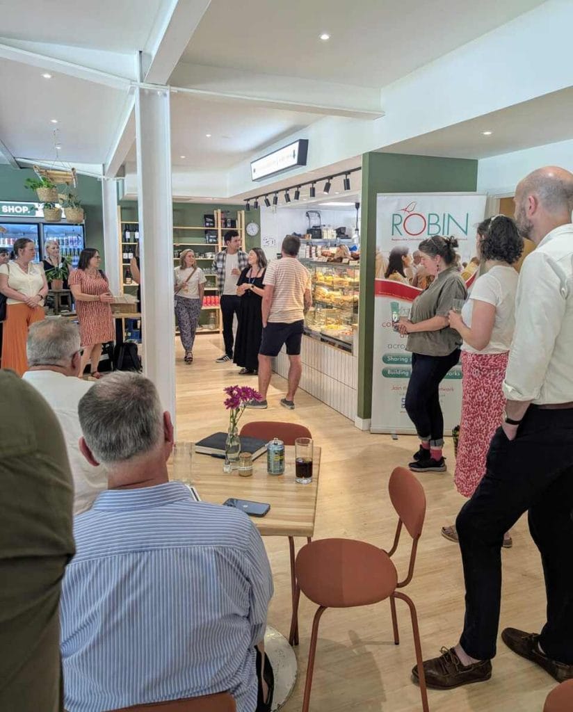 Attendees seated at tables chatting in a bright open venue