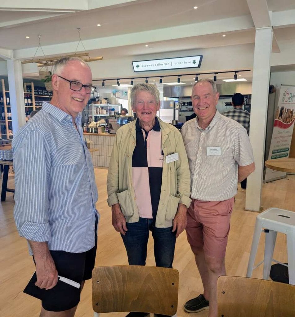 Group of attendees standing and chatting at the Elmfield exhibition